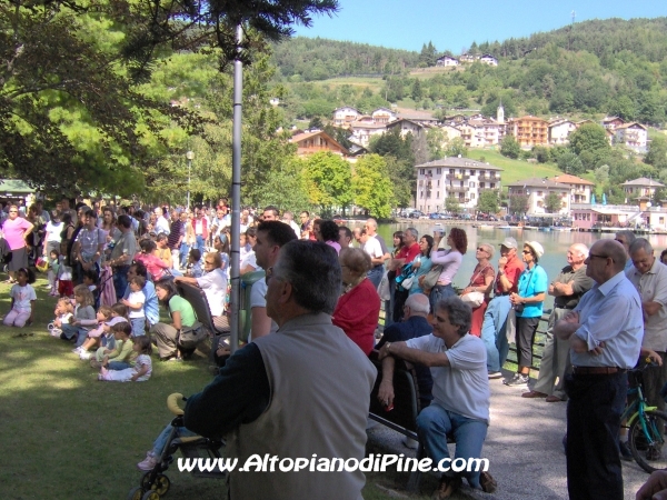 La gente che ascolta il concerto in riva al lago