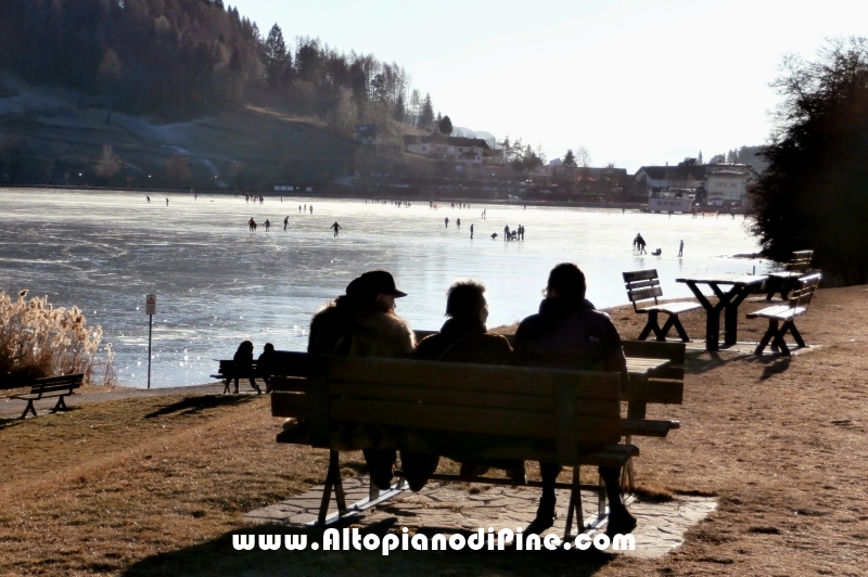 Chi si gode il sole e guarda gli altri sul lago ghiacciato della Serraia